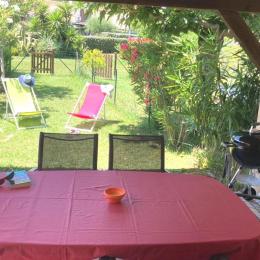 La terrasse couverte côté jardin avec table et chaises pour les repas et la détente en extérieur. - Location de vacances - Poggio-Mezzana