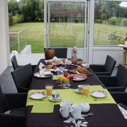 petit déjeuner dans la véranda avec vue sur le jardin et les pics-vert - Chambre d'hôtes - Rang-du-Fliers