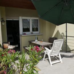 Terrasse de plein pied donnant sur la cuisine avec barbecue et parasol - Location de vacances - Cernay